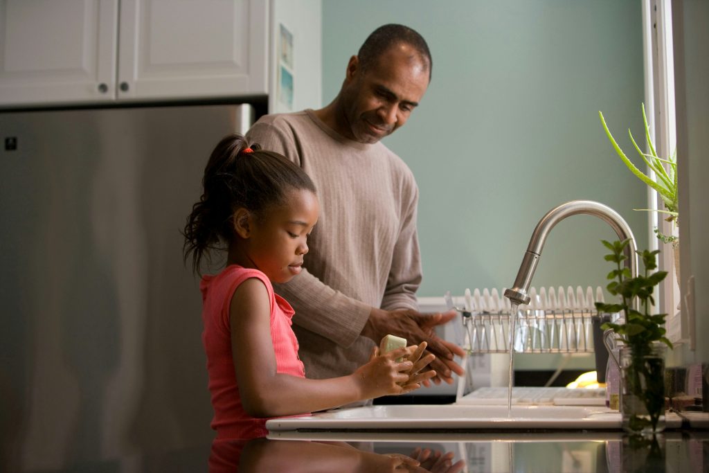 Parent with child at sink